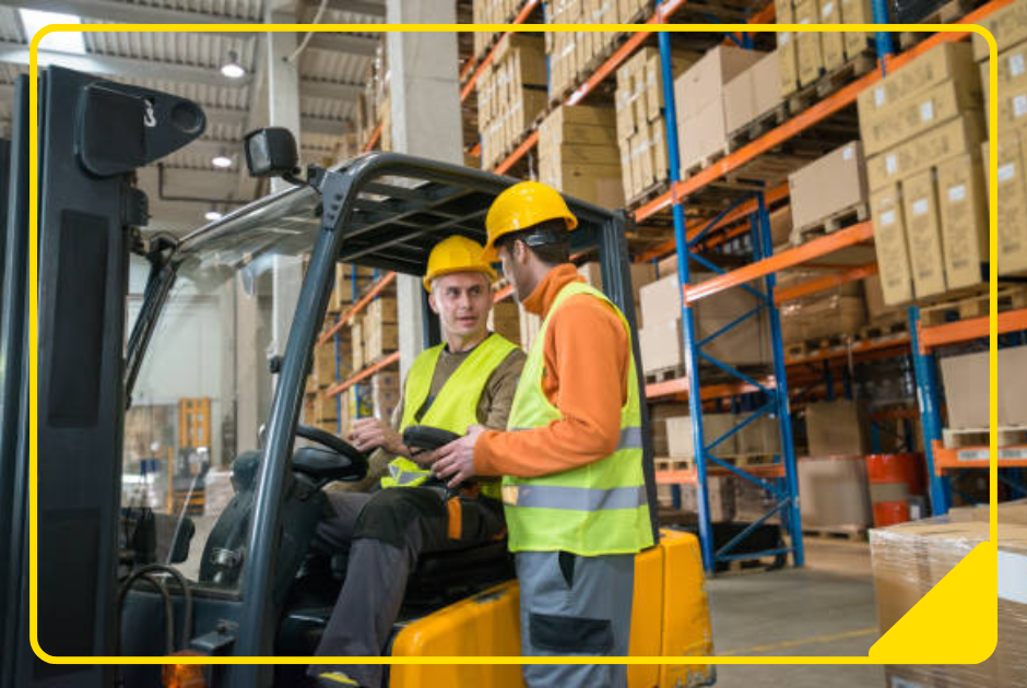 Gabelstaplerfahrer sitzt in seinem Gabelstapler und bespricht sich mit Lagermitarbeiter
